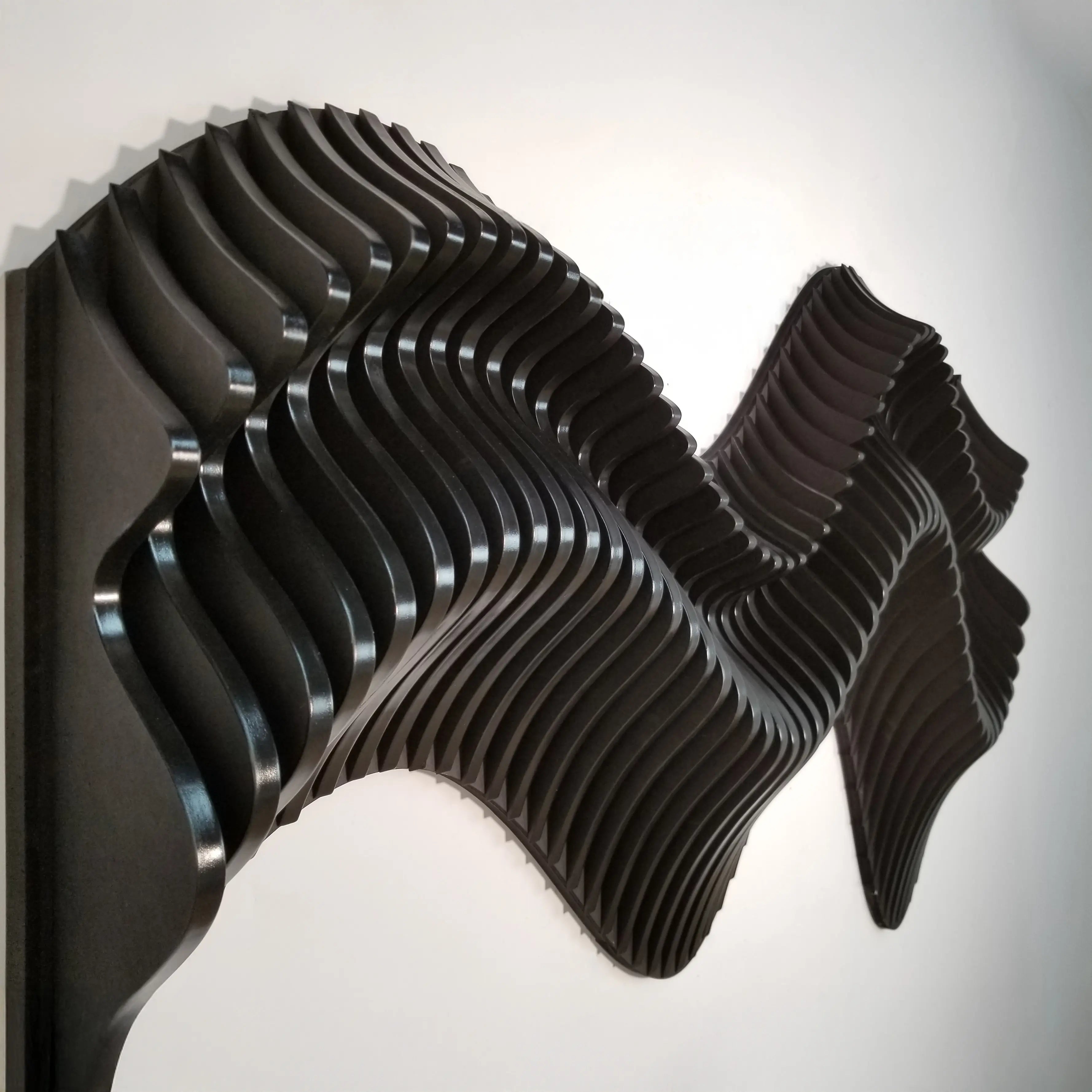 Black wavy wall art piece on a white background